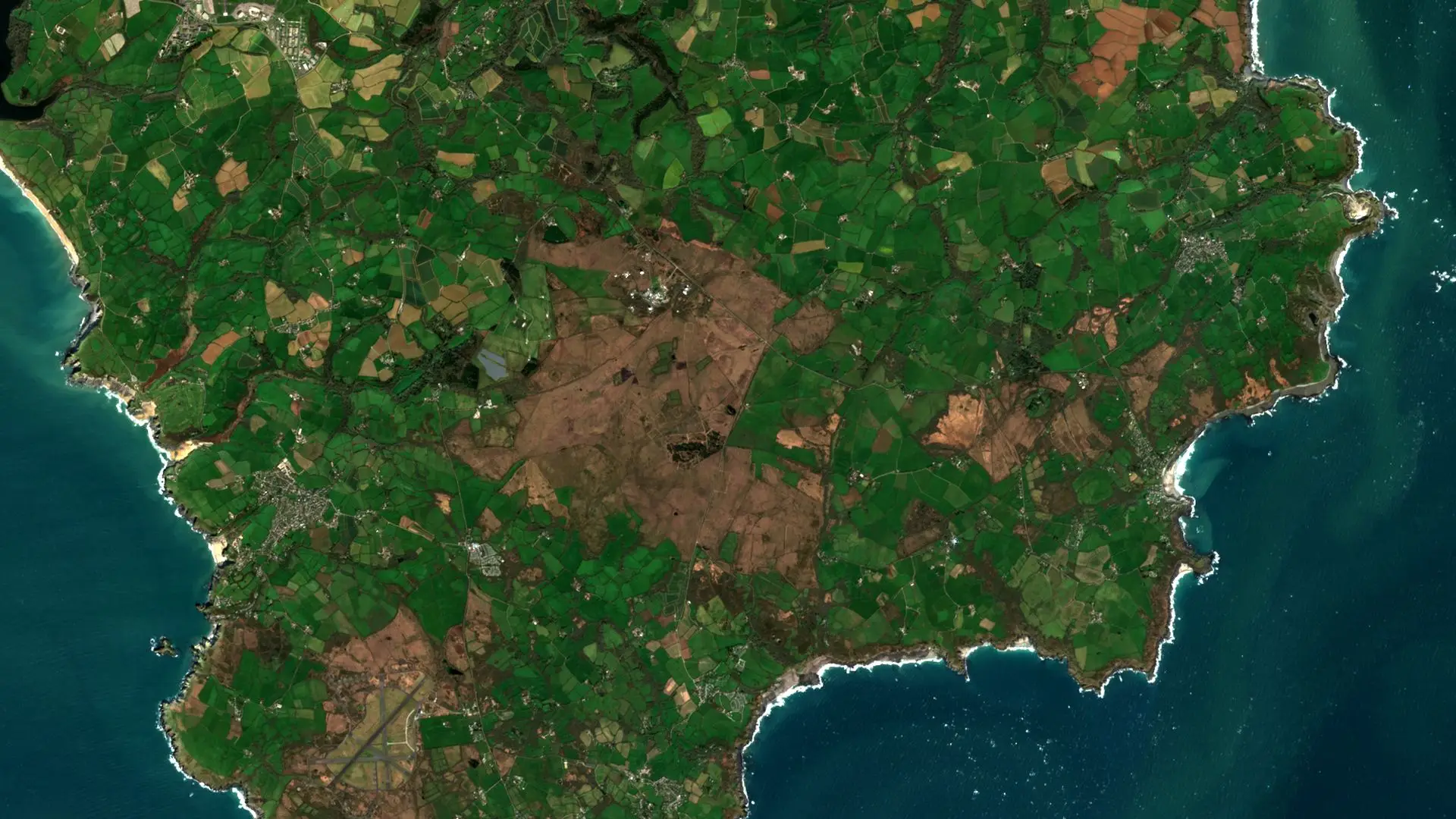 Sentinel-2 image of the Lizard peninsula in Cornwall, with the brown heath of Goonhilly Downs, home to Goonhilly Earth Station, among green fields, and turquoise sea along the coast. Goonhilly Downs and the Lizard, Cornwall, 19 March 2026