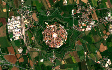 Sentinel-2 view of Palmanova in Friuli, the nine-pointed star fortress town, with its radial streets and central square inside rings of moats and bastions, among fields and newer suburbs