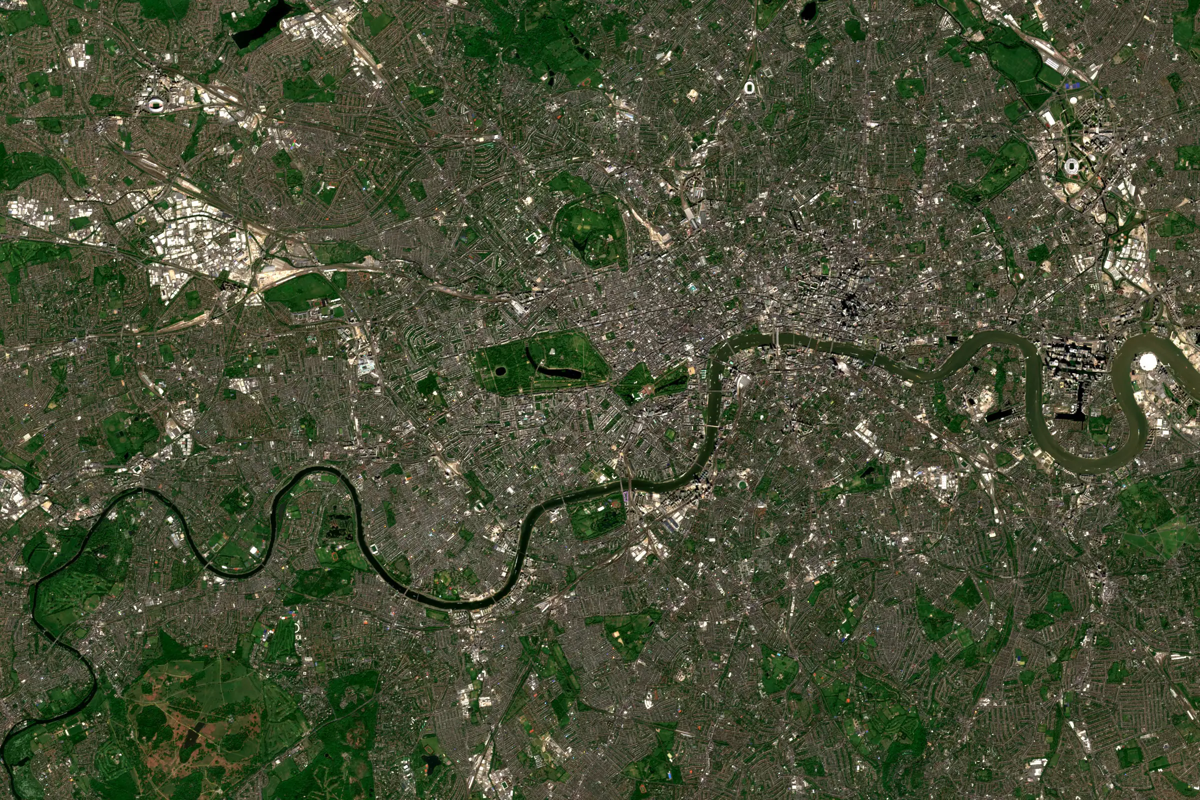 Satellite view of central London, with the River Thames winding through dense streets, parks and docklands