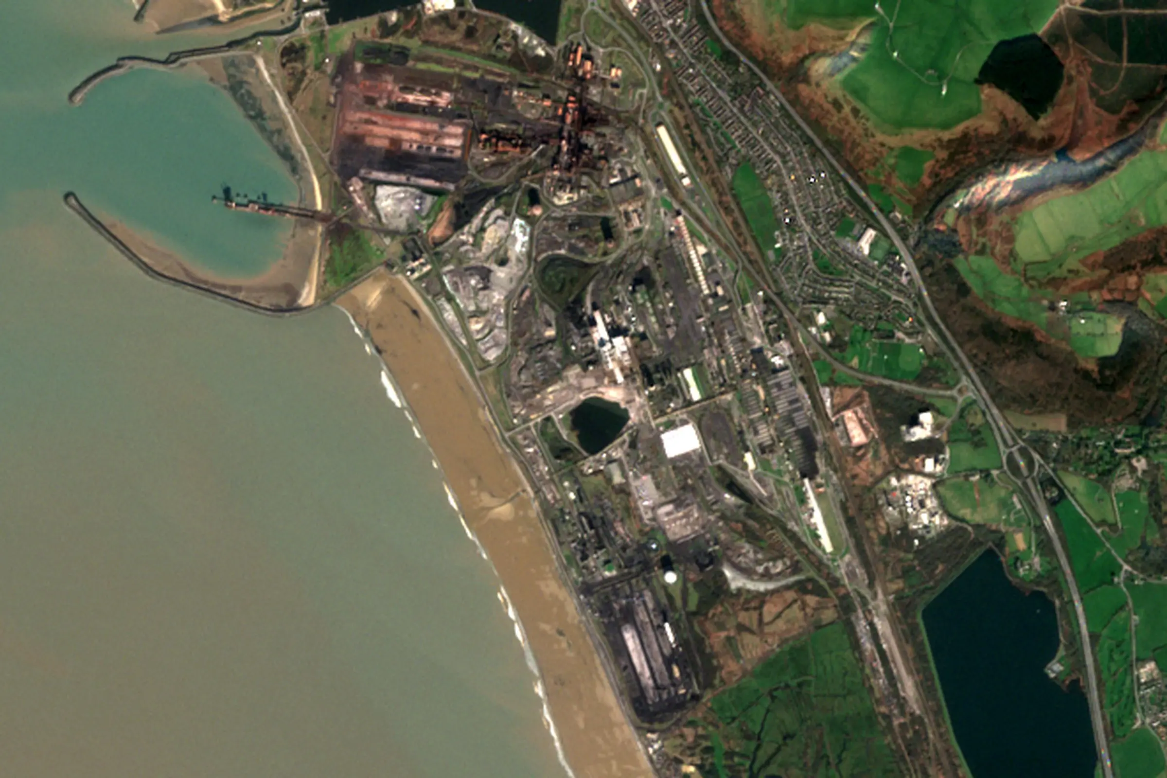 Satellite view of the Port Talbot steelworks on the Welsh coast, with the blast furnaces, ore yards and the deep-water harbour beside Aberavon beach